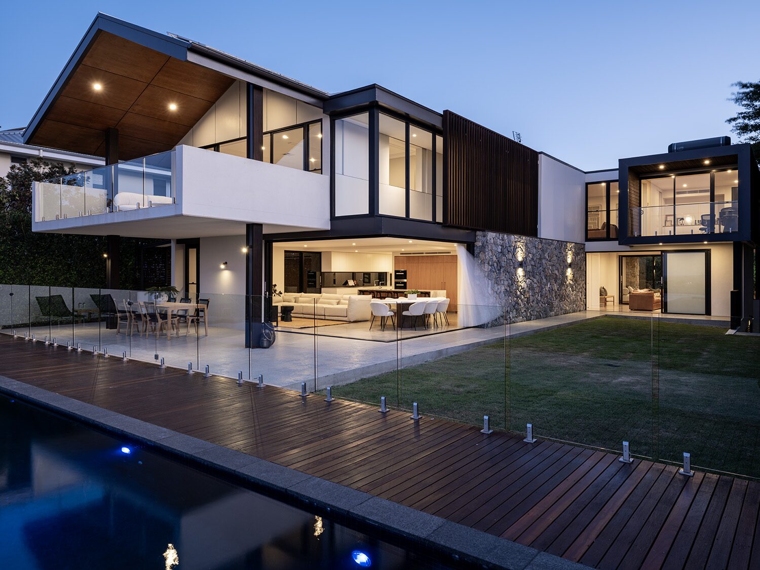 Amaroo — rear facade at dusk, pool and living beyond