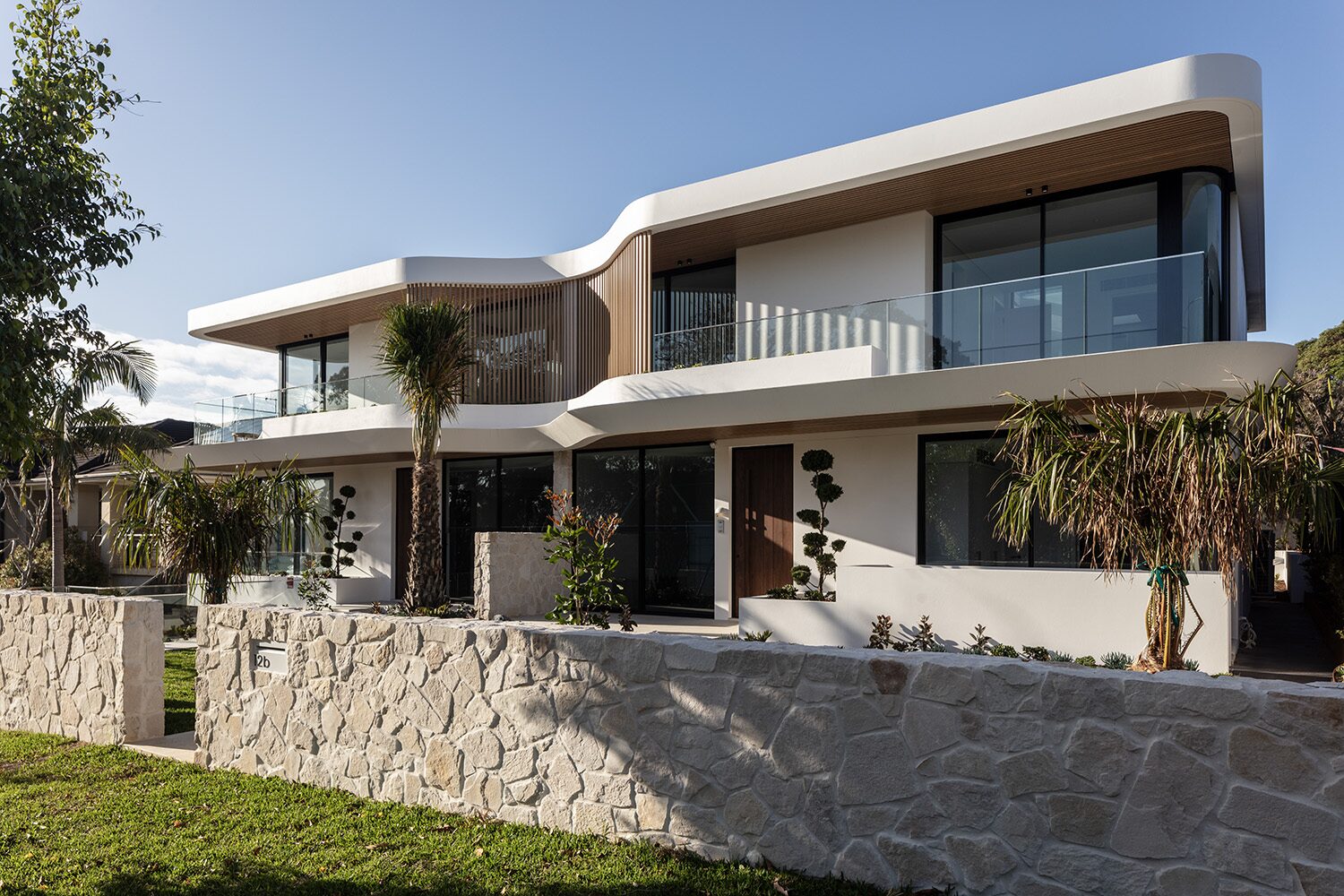 Binaville — front facade, curved render and stone garden wall