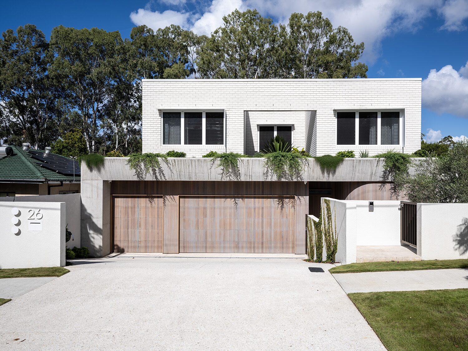Canopus 2.0 — front facade, white brick and timber garage