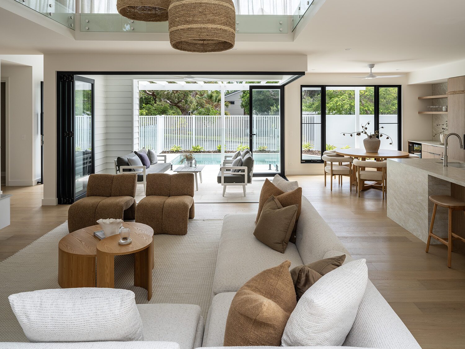 Noosaville — open-plan living, kitchen and pool beyond