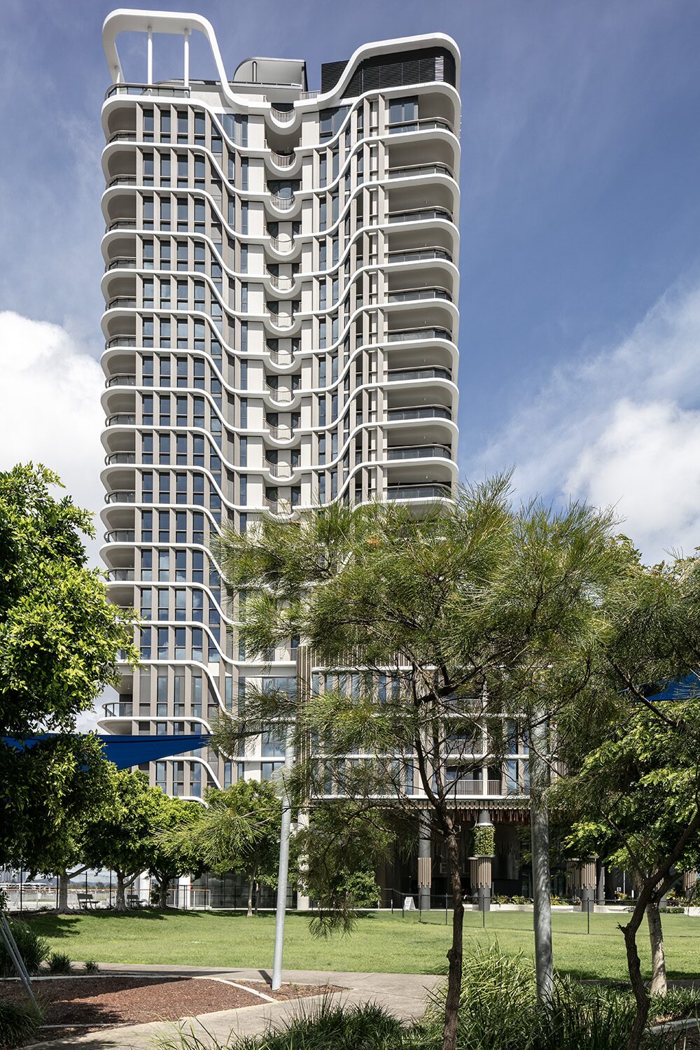 Rivello Residences — tower viewed from the riverside parkland