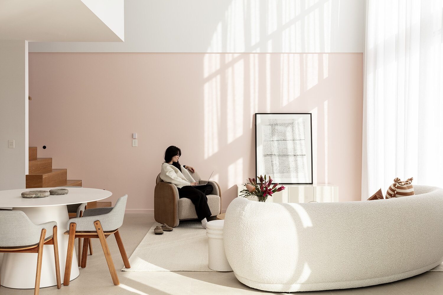 Sway — living room, blush feature wall and curved sofa