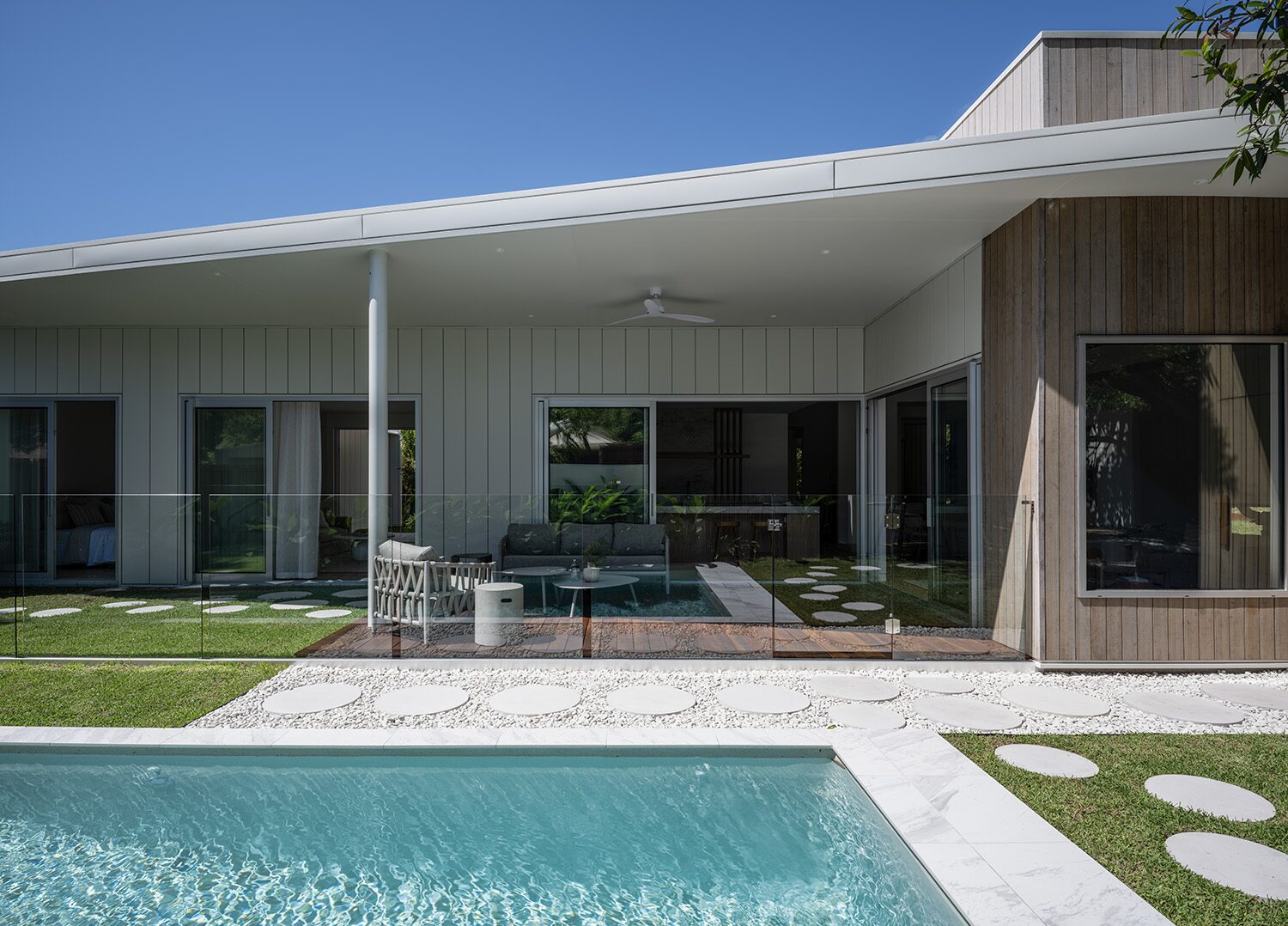 Tarina — pool terrace, timber-clad wing and glass fencing
