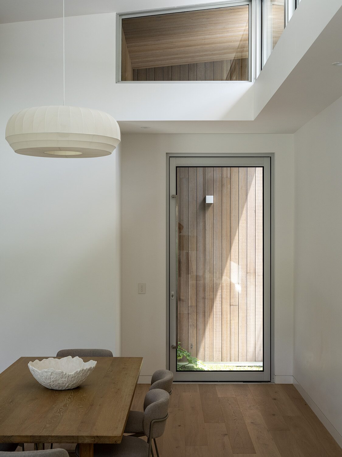 Tarina — dining area, timber entry door beyond